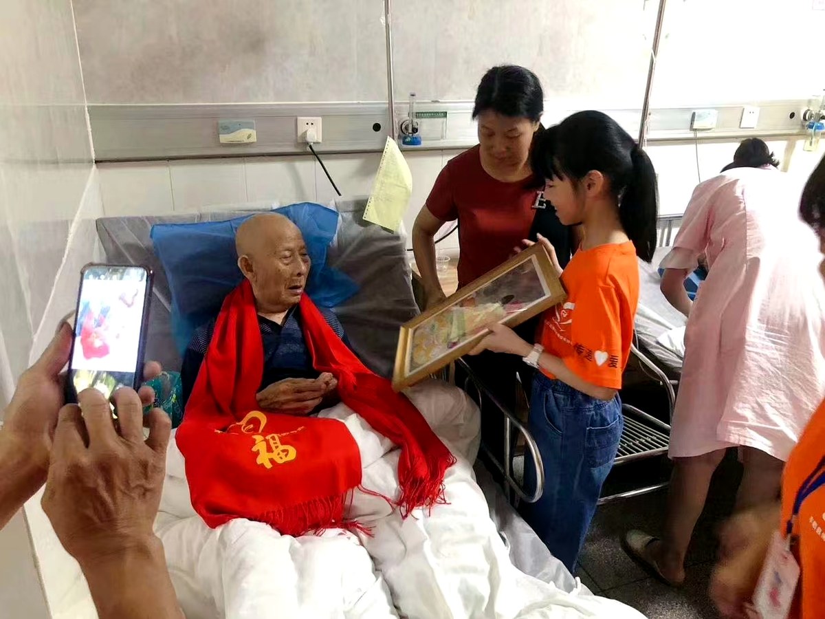 孩子把亲手绘制作品赠送给老人